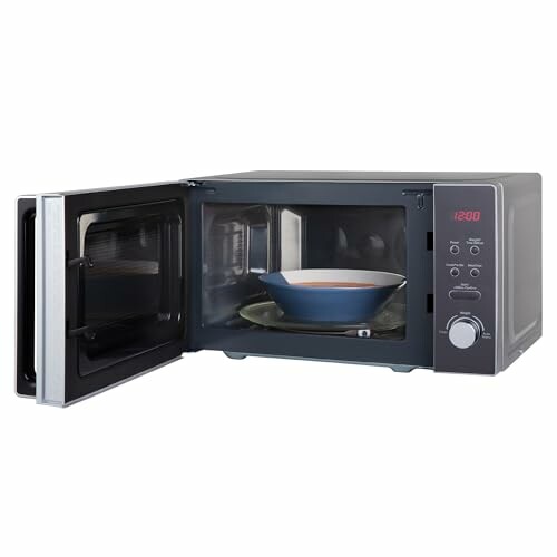 Microondas con puerta abierta y plato dentro.